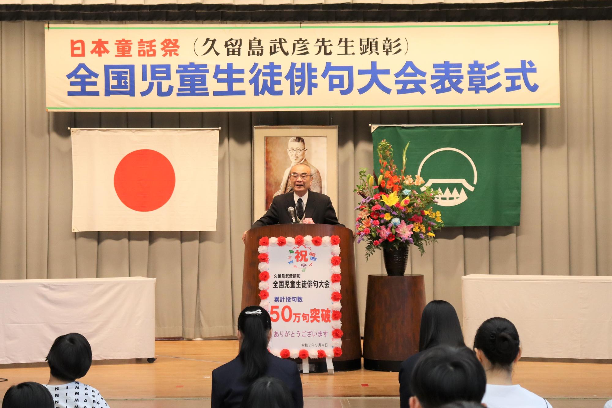 第42回俳句大会表彰式で講評を述べる大会選者牧野桂一先生の写真