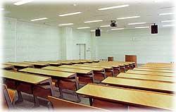 部屋の奥中央に教壇があり、そこに向くように設置された机が多数ある大学の講義室のような視聴覚室の写真