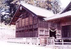 建物の周りに柵がある木造の末廣神社本殿を左斜めから撮影した写真