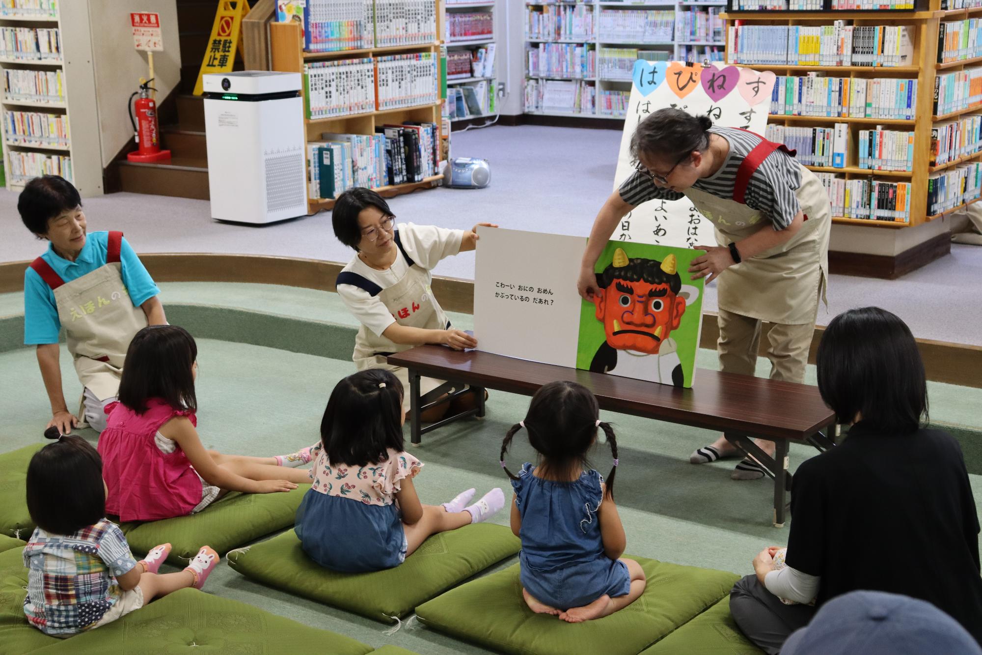 えほんの会はぴねすのみなさんが、絵本の読み聞かせをしている写真