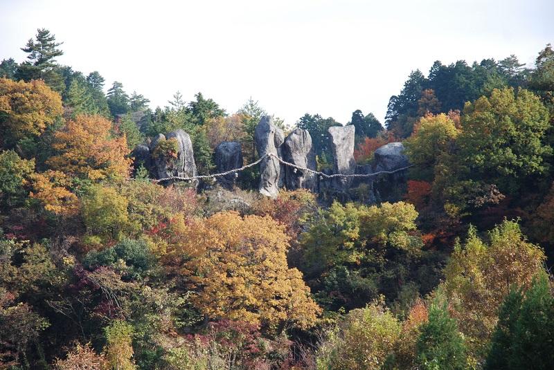 谷河内の景にある木々と、七福神として奉られている東奥山七福神の岩が写っている写真
