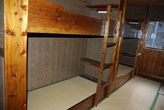 棚が内部にあり、畳敷きになっている宿泊室の2段ベッド内部の様子の写真