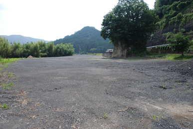 脇に道路と線路がある砂利の地面の空き地の写真