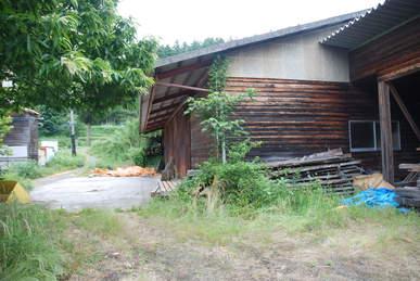 コンクリート地面の庭が併設されている木造の建物の写真