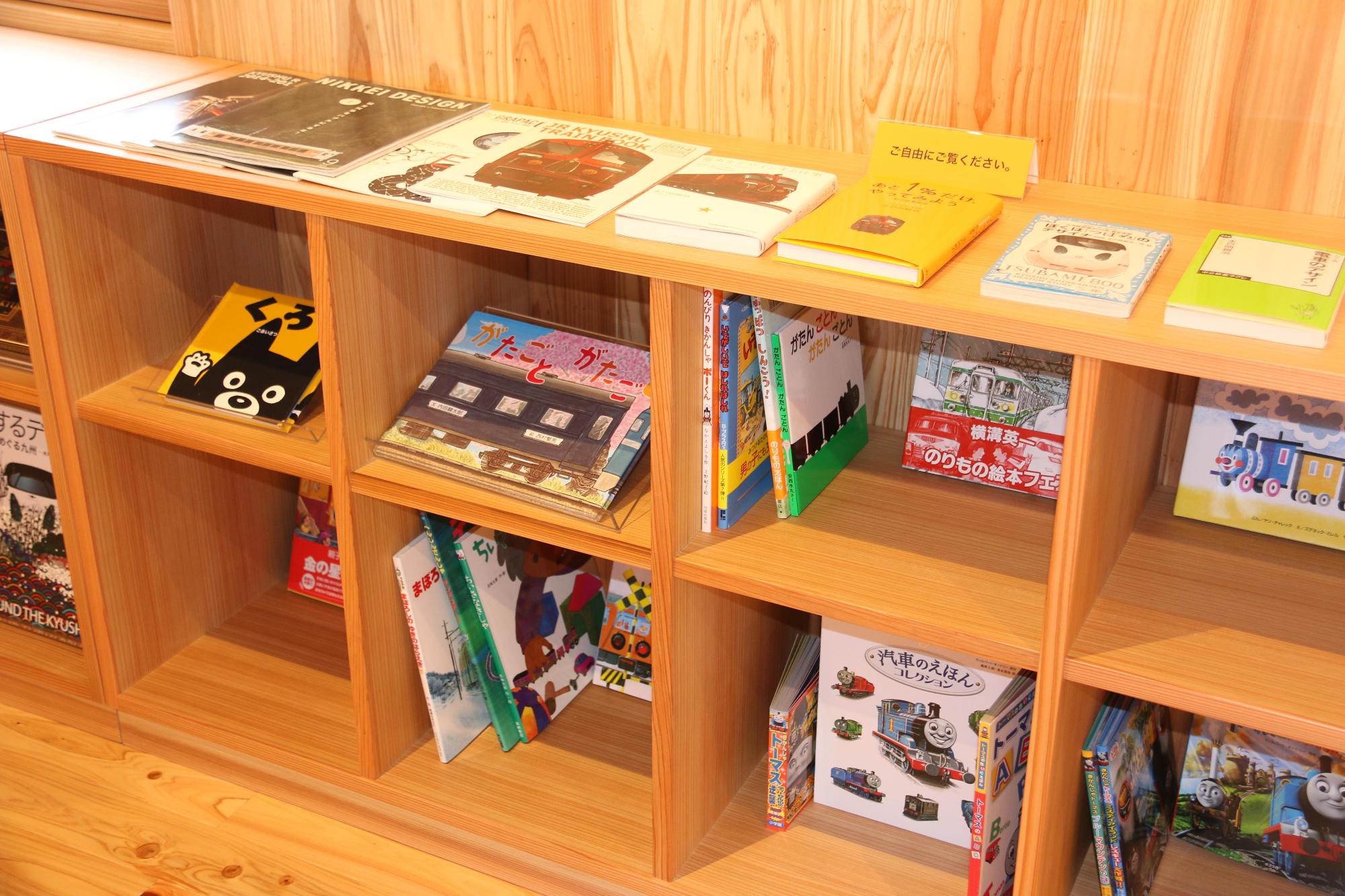 豊後森機関庫ミュージアム内にある、列車の本などが置かれている明るい茶色の本棚が写っている写真